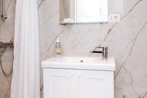 a bathroom with a white sink and a shower curtain at Appartement Babette in Zandvoort