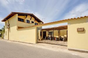 une maison jaune avec une terrasse en face de celle-ci dans l'établissement Il Corbezzolo, à Palmas Arborea