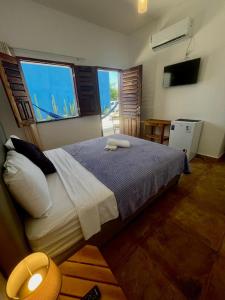 a bedroom with a large bed and a large window at Casa da Juma in Fortim