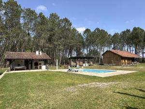 un gran patio con una casa y una piscina en Lou coutiot, en Linxe