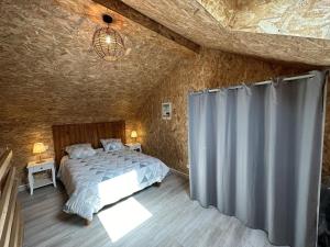 - une chambre avec un lit et un rideau dans l'établissement Lou coutiot, à Linxe