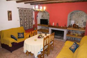 uma sala de estar com uma mesa e um sofá amarelo em Cortijo Villarosa em Benablón