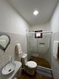 a bathroom with a shower and a toilet and a sink at Casa da Juma in Fortim