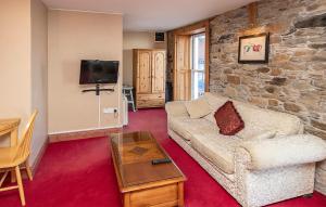 sala de estar con sofá y pared de piedra en The Ormond Apartments en Dungarvan