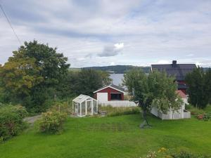 een tuin met een huis en een kas bij Unik eiendom i Gjøvik sentrum in Gjøvik