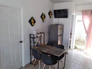 een keuken met een tafel en stoelen en een koelkast bij Hacienda 85 in Ahuachapán