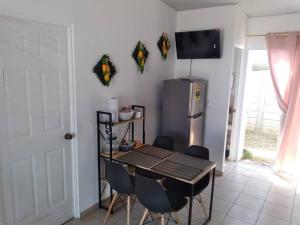 Una cocina con mesa y sillas y un refrigerador. en Hacienda 85, en Ahuachapán