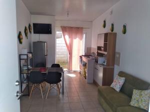 sala de estar con sofá, mesa y cocina en Hacienda 85 en Ahuachapán