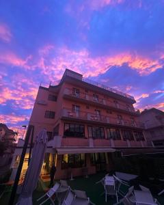 a building with a sunset in the background at Hotel Bel Sogno in Rimini