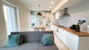 a living room with a couch and a kitchen at Farmont Seafront Acquamarine Suite by CaSa Check in Chioggia +36 photos