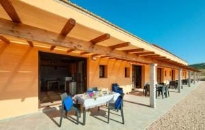 - un patio avec une table et des chaises blanches et un bâtiment dans l'établissement Lofts with private outdoor area and swimming-pool in Badesi, à Badesi