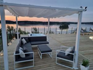 un patio con sofá y sillas en una terraza en House by the sea, en Söderköping
