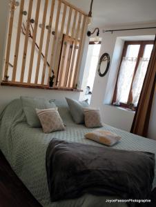 een slaapkamer met een groot bed met kussens erop bij Chambre d'hôte Au Jardin Le clos des vins d'Anges in Saint-Pierre-des-Champs