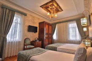 a hotel room with two beds and a chandelier at Blue House Hotel Old City - Sultanahmet in Istanbul