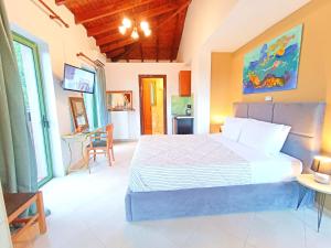 a bedroom with a large bed and a kitchen at Okeanis Apartments & Suites Adults Only in Katelios