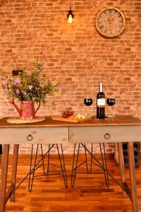 una mesa de madera con 2 copas de vino y una pared de ladrillo en Thumpers Cottage, en Kalawana