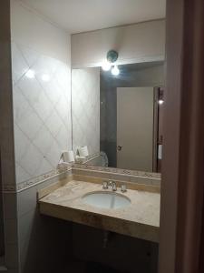 baño con lavabo y espejo grande en Departamentos Romano en Mendoza