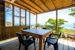 a wooden table and chairs on the porch of a house at Kalaloo Point in Providencia