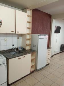 a kitchen with white cabinets and a white refrigerator at Departamentos Romano in Mendoza