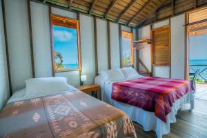 two beds in a room with two windows at Kalaloo Point in Providencia