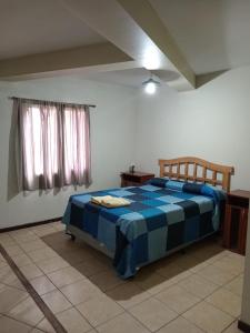 Un dormitorio con una cama azul y blanca en una habitación en Departamentos Romano en Mendoza