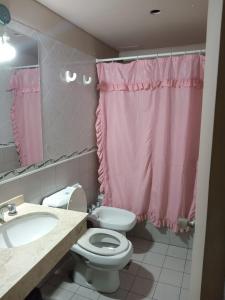 baño con cortina de ducha rosa y aseo en Departamentos Romano en Mendoza