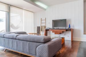 a living room with a couch and a tv at Azores Dreams - Sea View House in São Roque