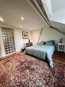 a bedroom with a bed and a large rug at Superbe duplex, Centre historique, 5 personnes in Bellême