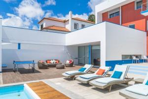 a patio with chairs and a pool in front of a house at Azores Dreams - Sea View House in São Roque