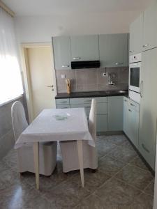 a kitchen with a table with a white table cloth on it at Apartman Centar in Modriča