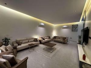 ein Wohnzimmer mit Sofas und einem Flachbild-TV in der Unterkunft ابيات فيلا in Riad