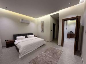ein Schlafzimmer mit einem großen weißen Bett und einem Spiegel in der Unterkunft ابيات فيلا in Riad