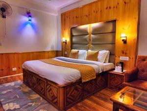 a bedroom with a large bed and a couch at Hotel Surya International - Manali in Manāli