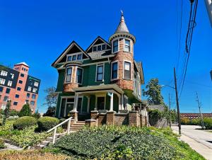 una casa verde con una torretta su una strada di The Villa on Meridian a Indianapolis