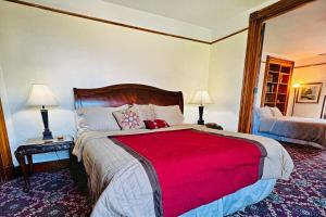 a bedroom with a large bed with a red blanket at The Villa on Meridian in Indianapolis