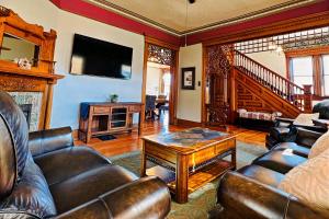 sala de estar con muebles de cuero y chimenea en The Villa on Meridian, en Indianápolis