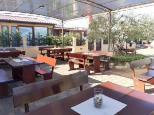 a patio with wooden tables and benches at Monte studio app 3 in Umag