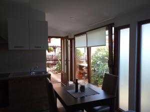 a kitchen with a table and a dining room with windows at Monte studio app 3 in Umag