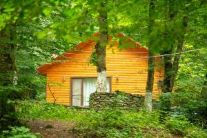 ein orangenes Haus mitten im Wald in der Unterkunft Aynur Resort in Quba