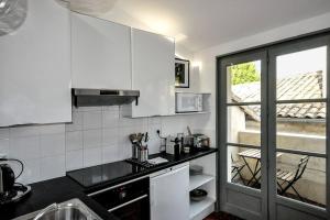 uma cozinha com armários brancos e uma bancada em L'Enclave em Avignon