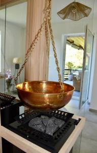 a bowl hanging from a chain on top of a stove at Wohlfühlhotel Sonnengarten in Überlingen