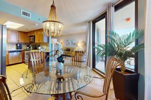 a dining room and kitchen with a glass table and chairs at Phoenix VI 807 in Orange Beach