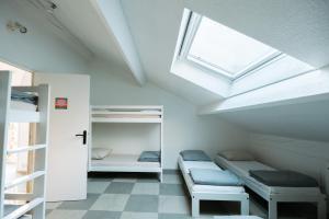 a dorm room with bunk beds and a skylight at Gîte de groupe "La Donaclaudré" pour vos événements en pleine nature - 15 à 120 personnes proche de Disneyland Paris in Saint-Augustin