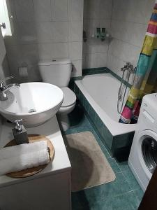 ein Badezimmer mit einem Waschbecken, einem WC und einer Badewanne in der Unterkunft Lenia's seaside apartment in Faraí