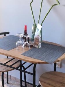 einen Tisch mit zwei Flaschen Wein und einer Vase in der Unterkunft Lenia's seaside apartment in Faraí