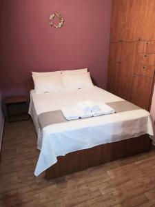 ein Schlafzimmer mit einem Bett mit zwei Handtüchern darauf in der Unterkunft Lenia's seaside apartment in Faraí