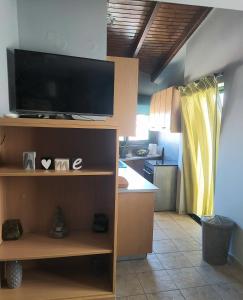 eine Küche mit einem Flachbild-TV auf einem Regal in der Unterkunft Lenia's seaside apartment in Faraí
