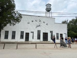 ein weißes Gebäude mit einem Wasserturm darüber in der Unterkunft Comal Rive Pool Gruene Hall by Barclé in New Braunfels