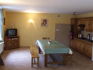 a living room with a table and a kitchen at Les Abris de la Sée in Tirepied