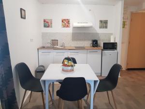 kuchnia ze stołem z krzesłami i ciastem w obiekcie Appartement en entier w mieście Saint-Junien